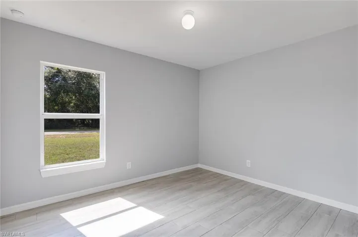 Spare room with baseboards and light wood-style floors