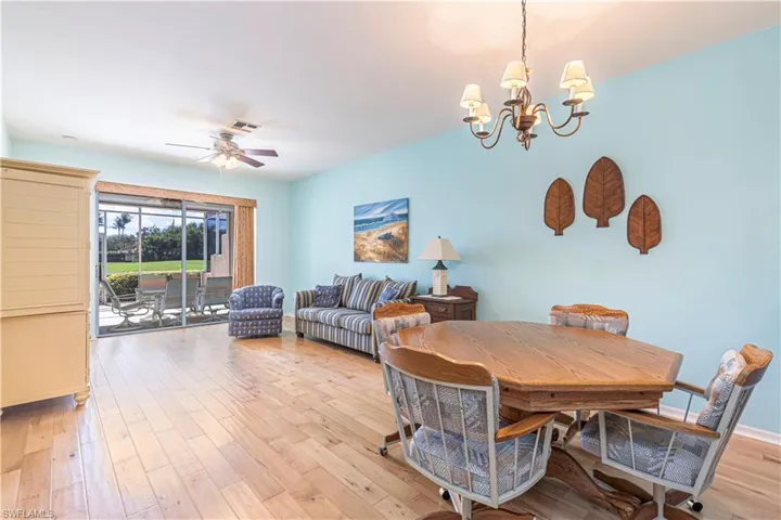 Dining room with light wood-style flooring, a chandelier, and ceiling fan