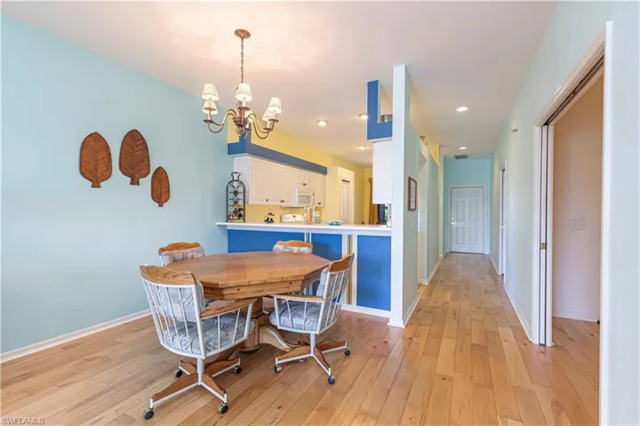 Dining space with light wood-style flooring, recessed lighting, and a chandelier