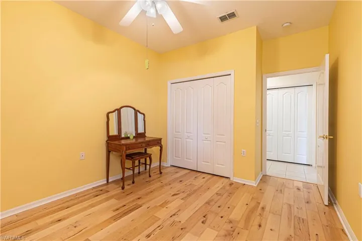 Bedroom with light wood-style flooring, a closet, and a ceiling fan