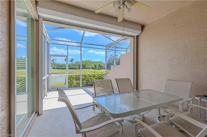 Sunroom with ceiling fan, outdoor dining space, and a water view