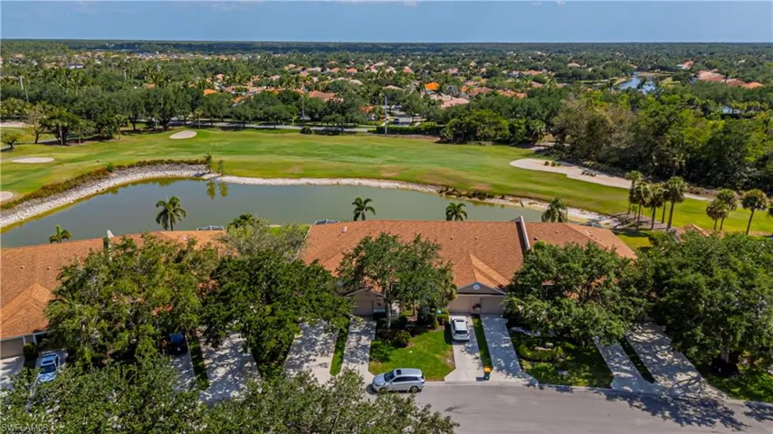 Aerial perspective of suburban area featuring a nearby body of water and a local golf course