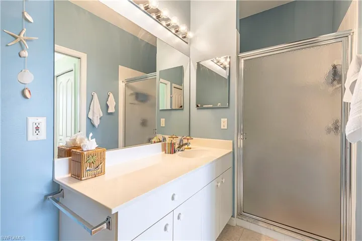 Master Full bathroom with a shower stall, vanity, and light tile patterned floors