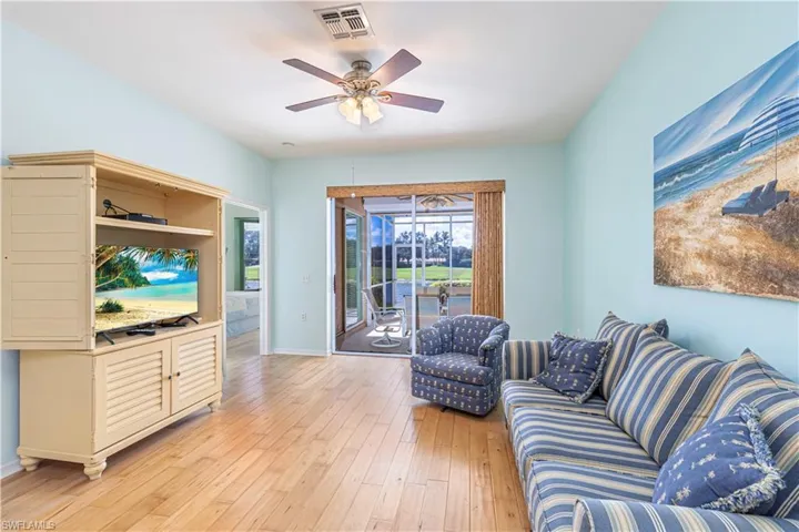 Living room with light wood finished floors and ceiling fan