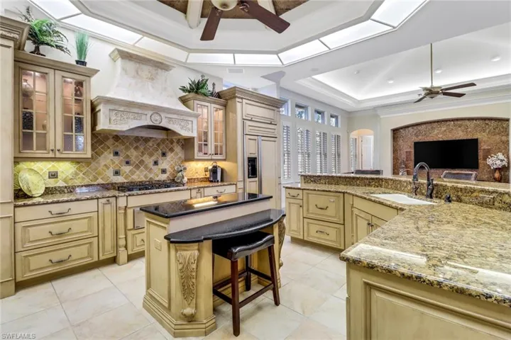 Kitchen featuring paneled fridge overlooking family room.