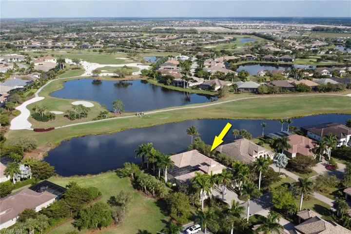 Aerial view featuring view of golf course, a water view, and a residential view