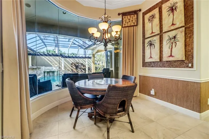 Tiled dining area featuring a wainscoted wall