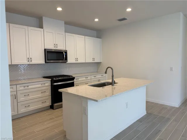 Beautiful kitchen layout with ample cabinetry, quartz countertops, and soft-close cabinets
