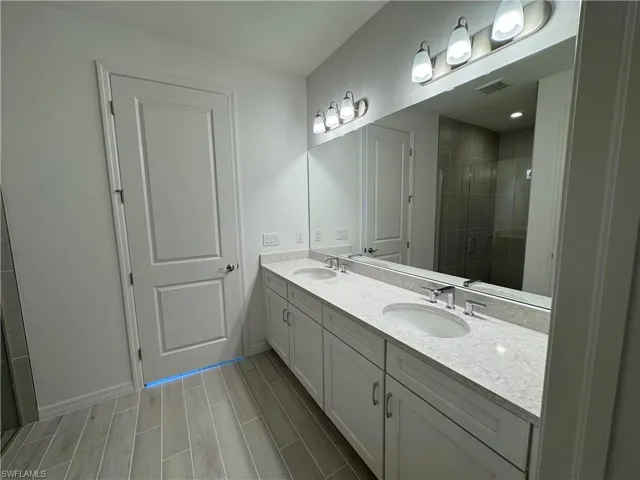 Primary bathroom with quartz countertops, dual-sinks, and soft-close cabinetry