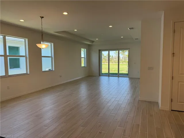 Great room living area with casual dining space and impact resistant glass doors that lead to covered lanai