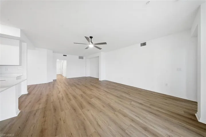 Unfurnished living room with light wood-type flooring and ceiling fan