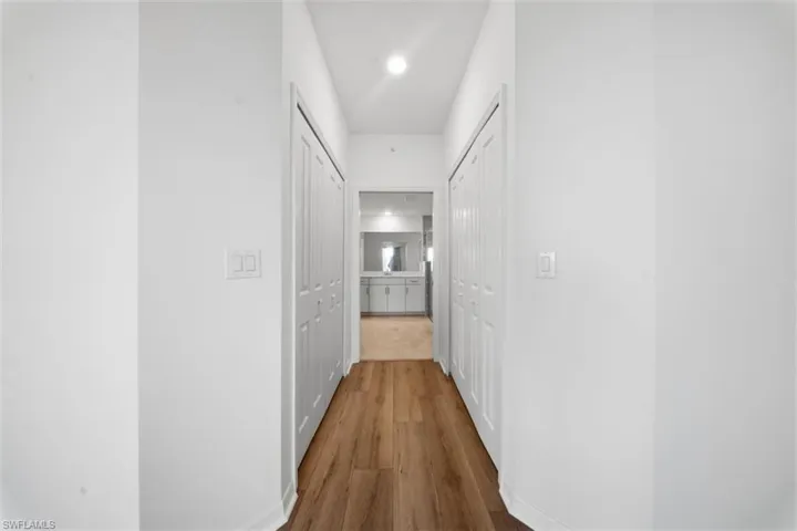Corridor featuring wood finished floors and recessed lighting