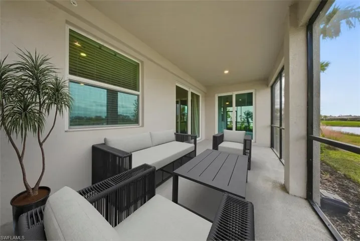 Sunroom with outdoor lounge area, a water view, and a patio
