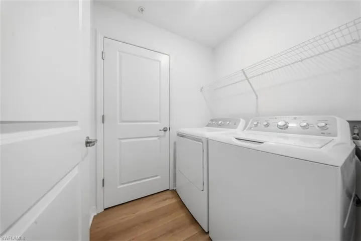 Laundry room with light wood-style flooring and washer and clothes dryer