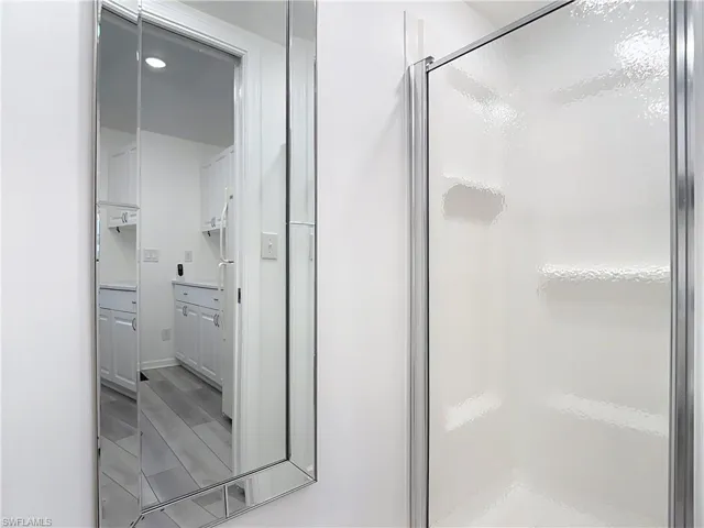Bathroom featuring a stall shower and wood finish floors