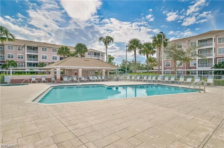 Rectangular swimming pool surrounded by a large paver deck