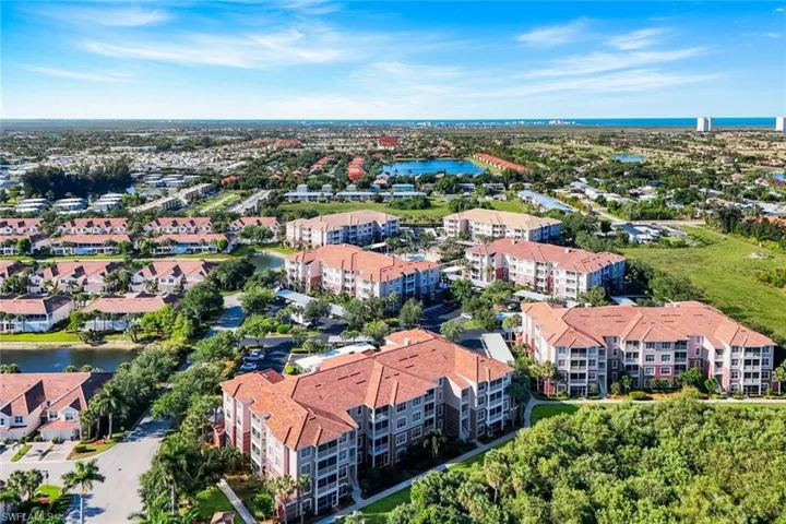 Aerial perspective showcasing a residential community with multiple multi-story buildings featuring red tile roofs