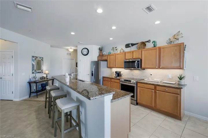 Kitchen featuring light wood cabinetry, stainless steel appliances, a tile backsplash, and recessed lighting