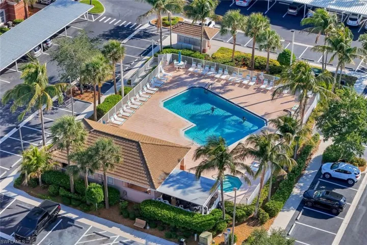 Community swimming pool with an integrated spa, surrounded by a spacious deck with lounge chairs