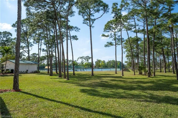 View of property's community with a water view and a lawn