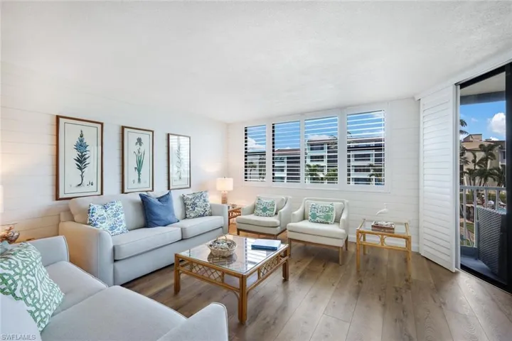 Living room with a textured ceiling, plenty of natural light, and hardwood / wood-style floors