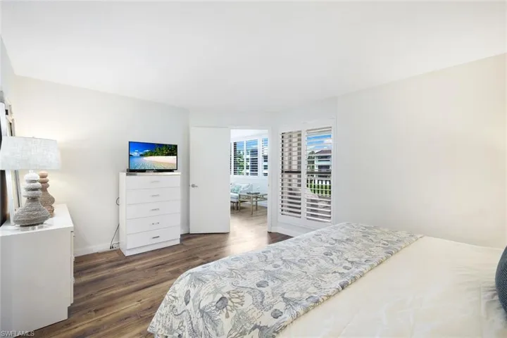 Bedroom with dark hardwood / wood-style flooring