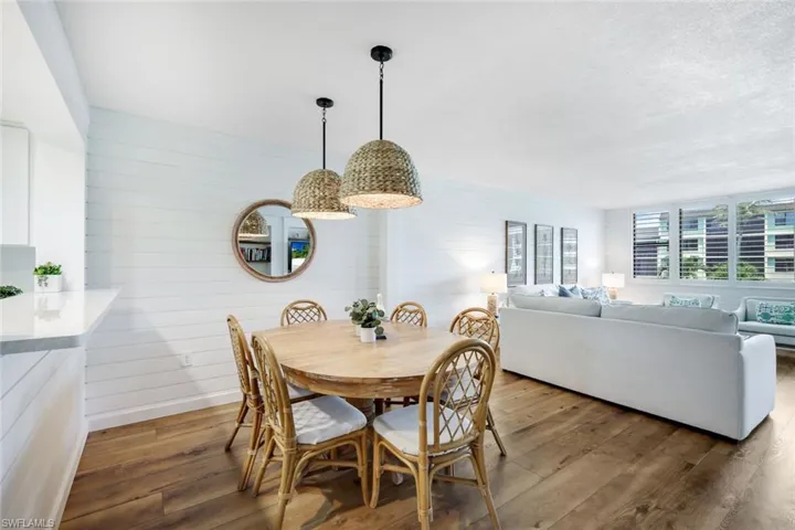 Dining area with wood walls, hardwood / wood-style flooring, and a textured ceiling
