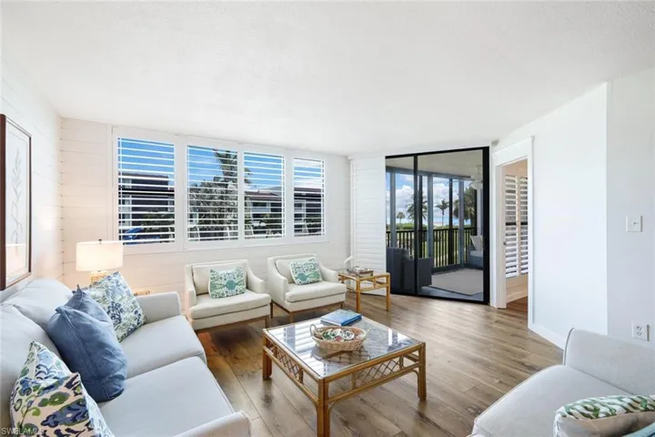 Living room featuring a textured ceiling, floor to ceiling windows, and hardwood / wood-style floors