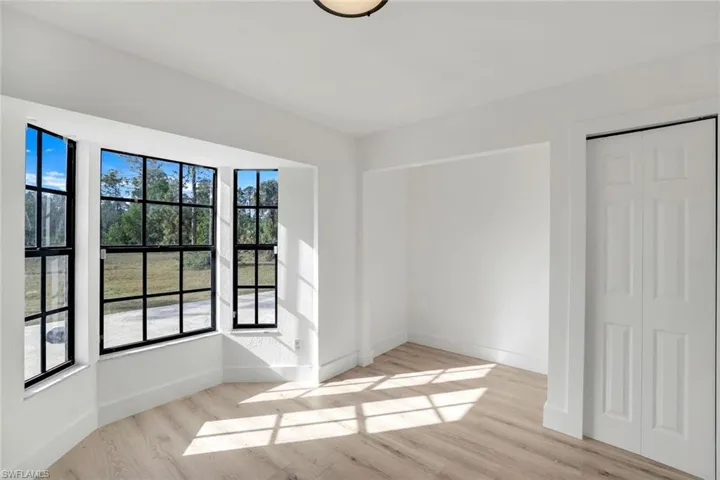 Empty room featuring plenty of natural light and light wood-type flooring