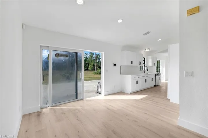 Unfurnished living room with sink and light hardwood / wood-style floors