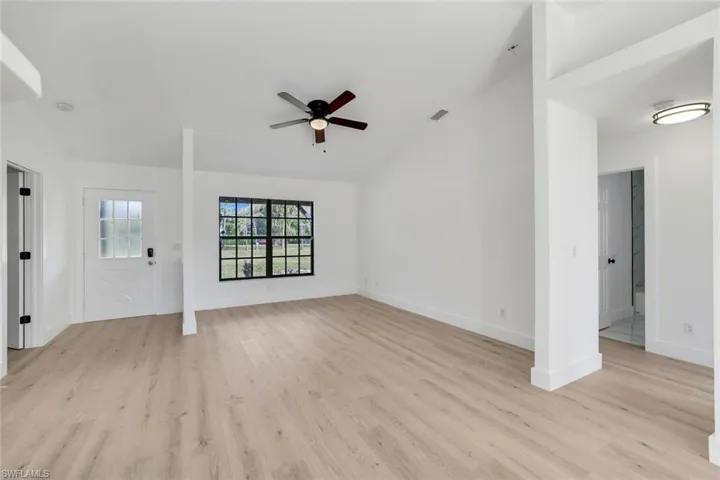Unfurnished living room with lofted ceiling, light hardwood / wood-style floors, and ceiling fan