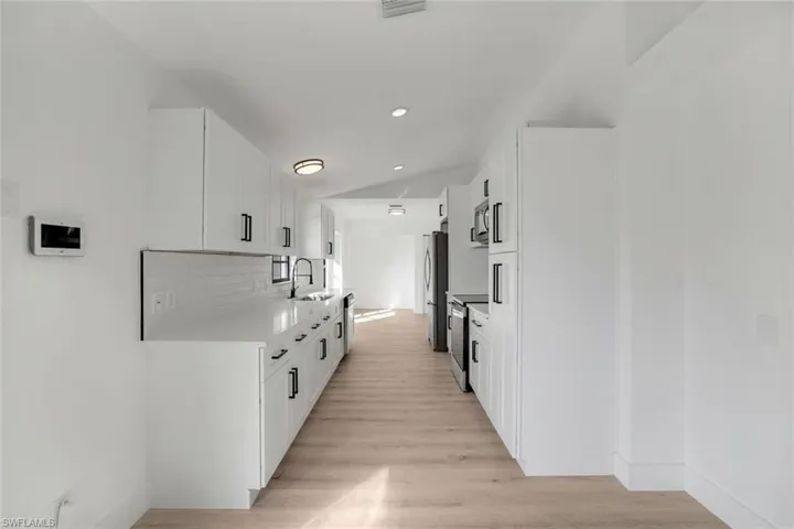Hall featuring sink and light wood-type flooring