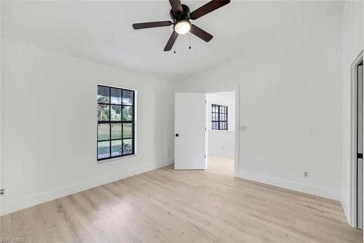 Empty room with ceiling fan, light hardwood / wood-style floors, and vaulted ceiling