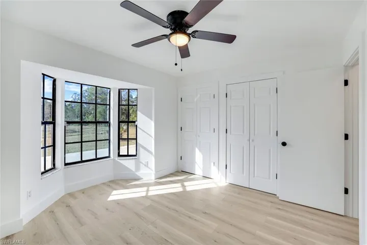Unfurnished bedroom with two closets, light hardwood / wood-style flooring, and ceiling fan