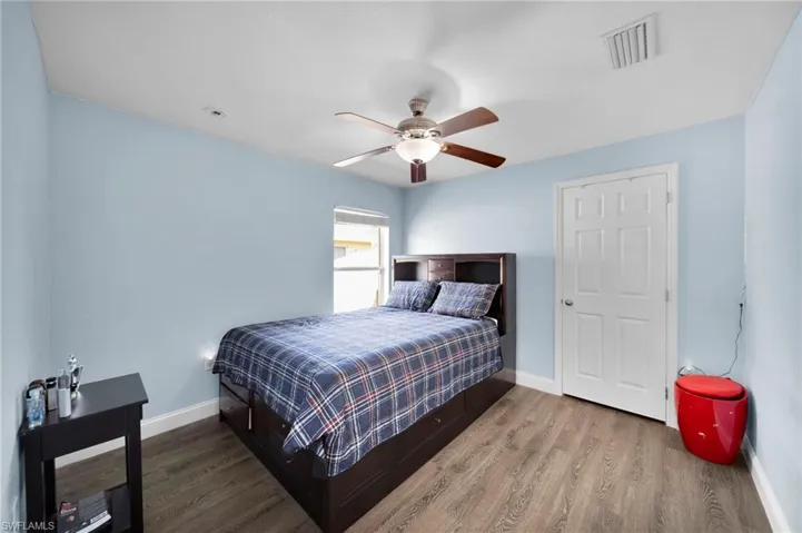Bedroom featuring visible vents, baseboards, and wood finished floors