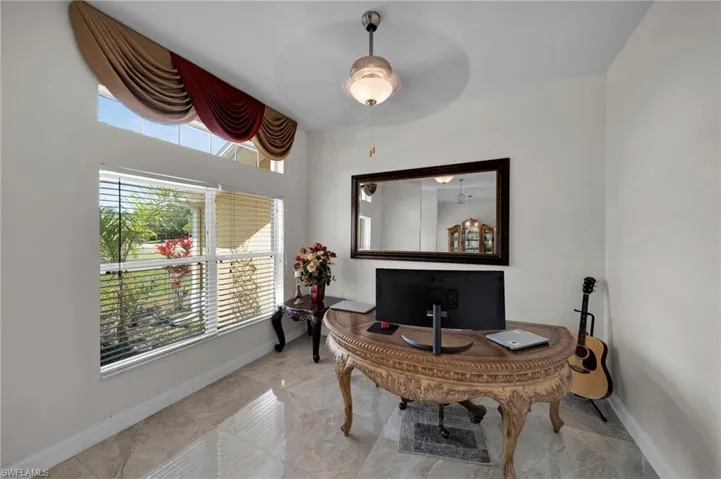 Office area with marble finish floor, ceiling fan, and baseboards