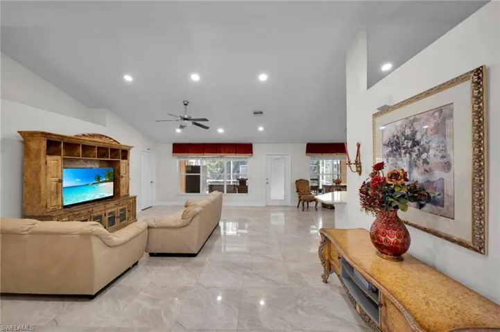 Living area featuring marble finish floor, baseboards, a ceiling fan, and recessed lighting