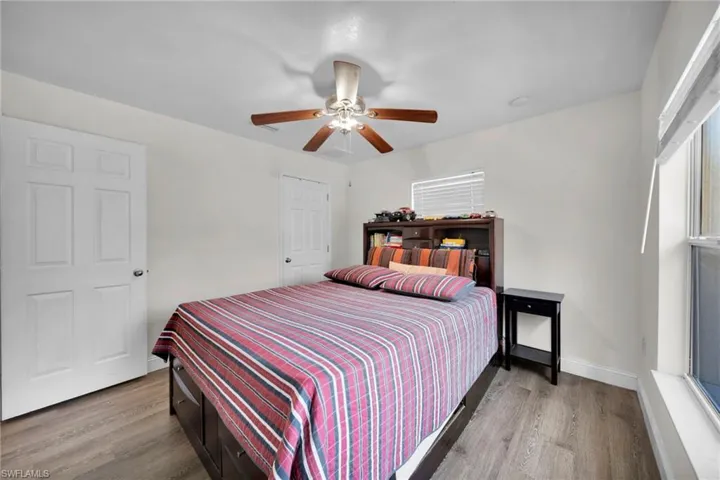 Bedroom featuring ceiling fan, wood finished floors, and baseboards