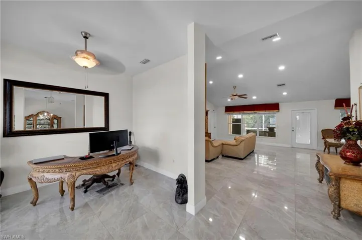 Office area featuring visible vents, baseboards, a ceiling fan, and marble finish floor