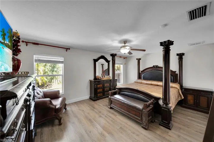 Bedroom featuring visible vents, baseboards, light wood finished floors, and ceiling fan