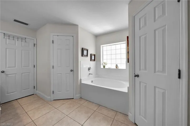 Full bath featuring visible vents, tile patterned floors, and a garden tub