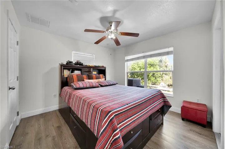 Bedroom with visible vents, baseboards, ceiling fan, and wood finished floors