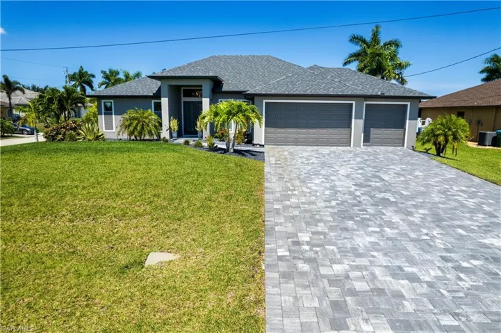View of front of house featuring a garage, central AC, and a front lawn