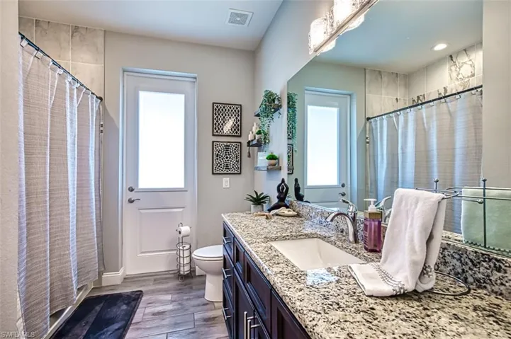 Bathroom with a healthy amount of sunlight, vanity, and toilet