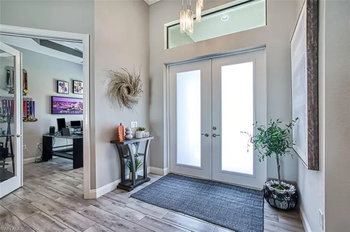 Foyer with french doors, ornamental molding, and light hardwood / wood-style flooring