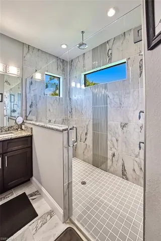 Bathroom with tile flooring, an enclosed shower, and large vanity