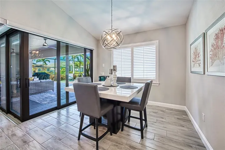 Dining room featuring a notable chandelier, lofted ceiling, and light hardwood / wood-style floors