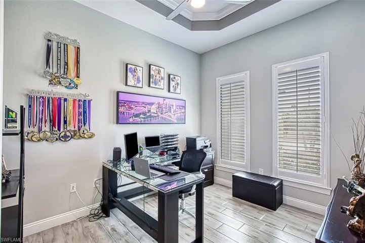 Office space with crown molding, light wood-type flooring, and ceiling fan