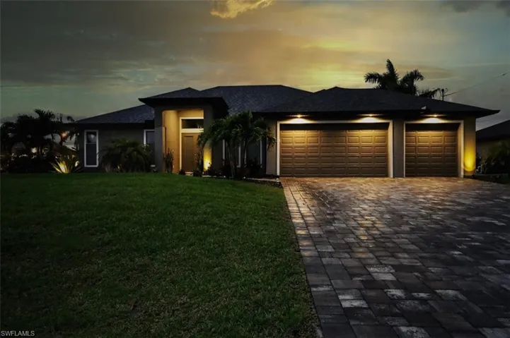 View of front of house featuring a garage and a yard