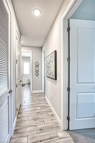 Hallway featuring light carpet